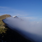 Luglio 2014 - La foto è stata scattata alcuni anni fa sulla cresta meridionale del Monte Baldo guardando verso Nord, in presenza di un forte vento occidentale in quota. Le nubi che si formavano sul versante Val d’Adige (banner clouds)salivano verso l’lalto, e, una volta giunte in cresta, non riuscivano a salire ulteriormente di quota e a valicare la cresta perchè spinte di nuovo verso est e verso il basso dal vento occidentale. L’effetto è ben visibile dalla foto: un confine netto tra nube e aria limpida proprio in prossimità della cresta.