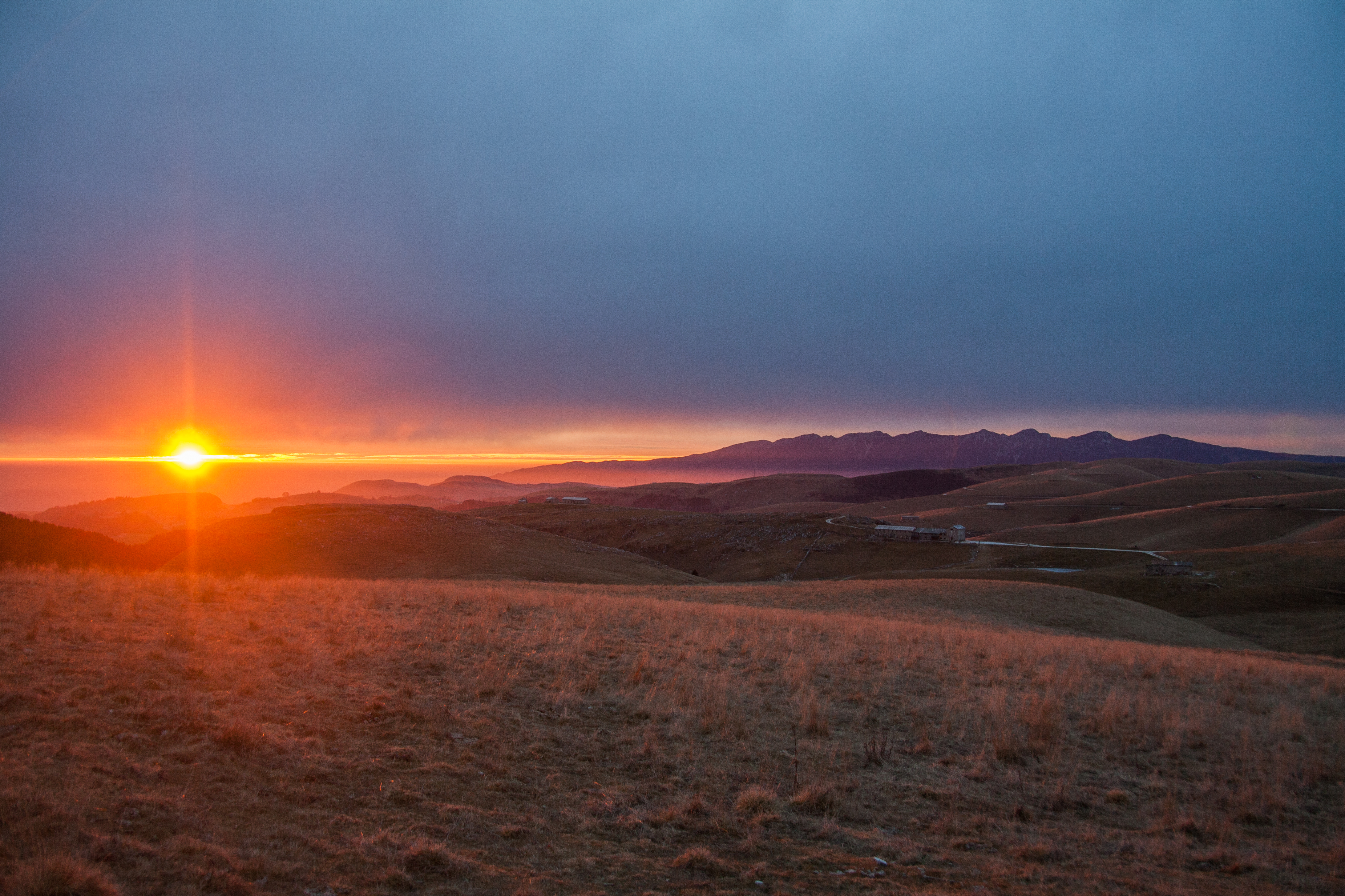 Dicembre 2015 - Nella bellissima foto di Luca Giavoni, il tramonto del 31 dicembre dalla Lessinia. Tra nubi alte in arrivo da ovest e foschie a bassa quota sulla pianura, gli ultimi raggi del 2015 esaltano il profilo del Baldo ancora senza neve.